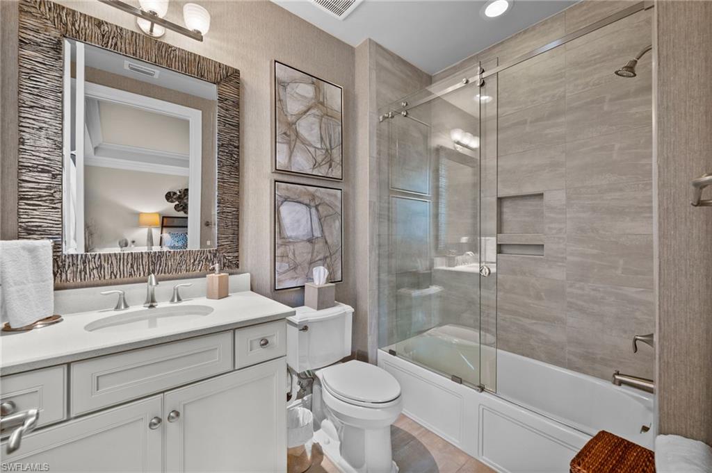 16436 Carrara Way, Unit 102 Naples, FL 34110 - Photo 24 of 43 Bathroom with shower / bath combination with glass door, vanity, and radiator