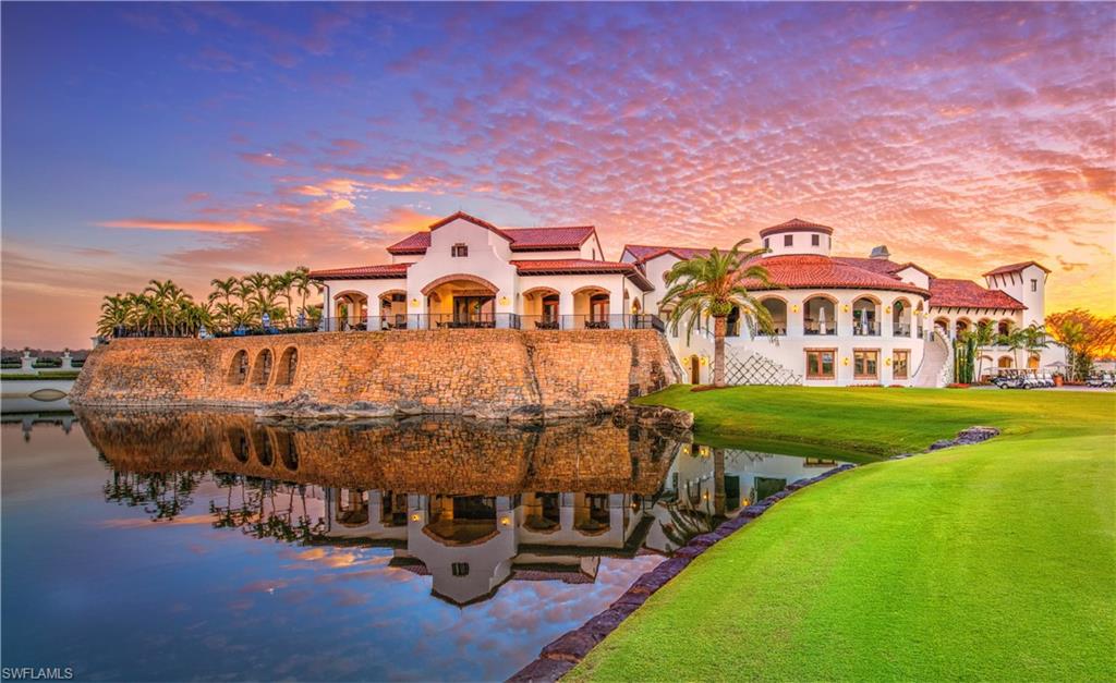 16436 Carrara Way, Unit 102 Naples, FL 34110 - Photo 36 of 43 Back of house at dusk featuring a balcony, stucco siding, a patio area, and a lawn