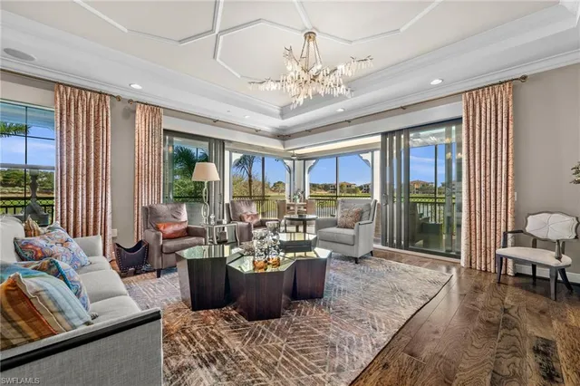 a living room with furniture large window and wooden floor