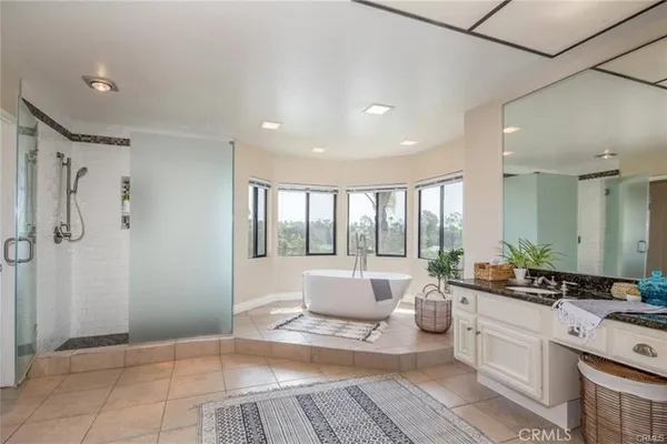 a spacious bathroom with a double vanity sink a large mirror and a bathtub