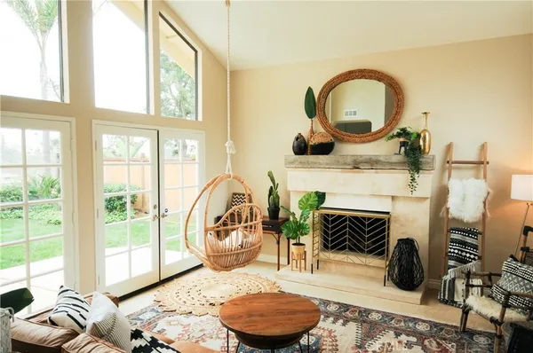 a living room with furniture a rug a fireplace and a large window