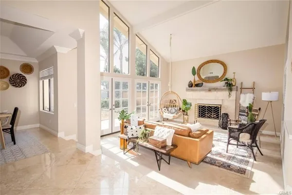 a living room with furniture a fireplace and a floor to ceiling window