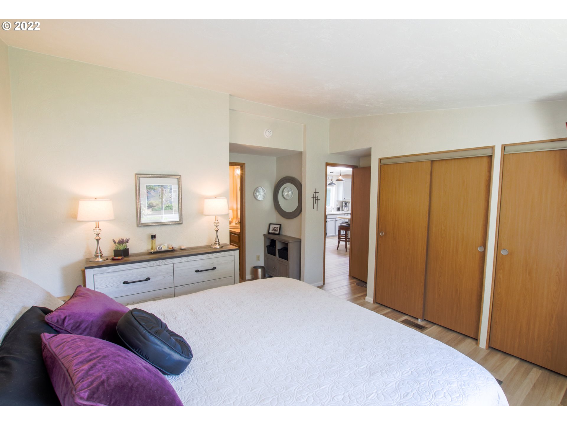 2187 12th Street Florence, OR 97439 - Photo 18 of 30 a spacious bedroom with a bed and a large mirror
