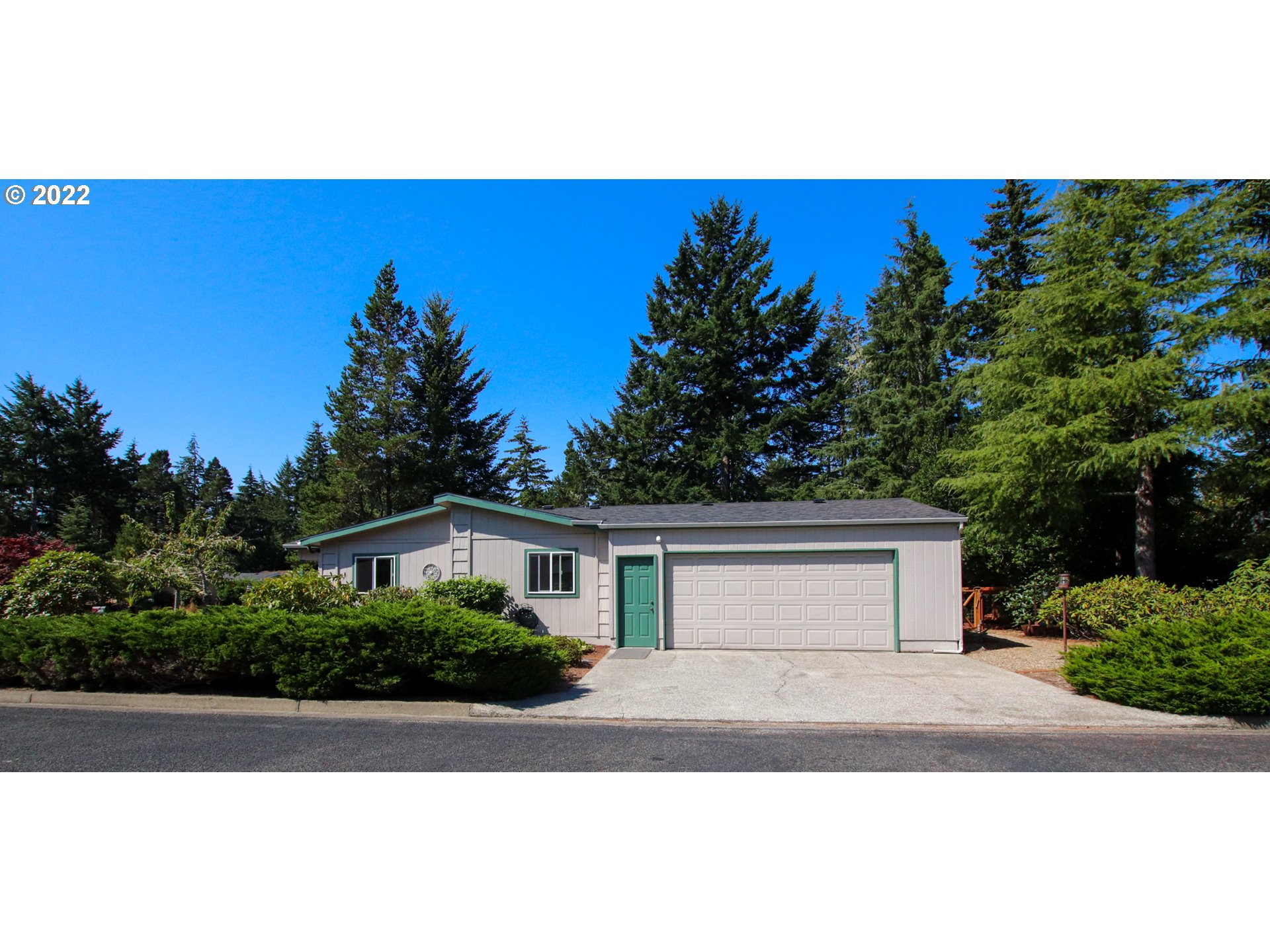 2187 12th Street Florence, OR 97439 - Photo 2 of 30 a view of house with yard and trees in the background