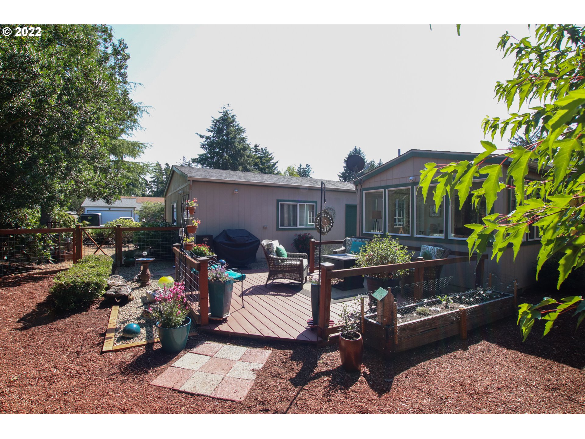2187 12th Street Florence, OR 97439 - Photo 4 of 30 a view of a patio with couches and a table and chairs with wooden fence