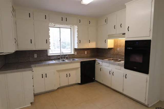 a kitchen with granite countertop white cabinets and white appliances