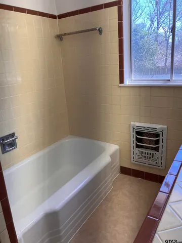 a bathroom with a bathtub and a shower