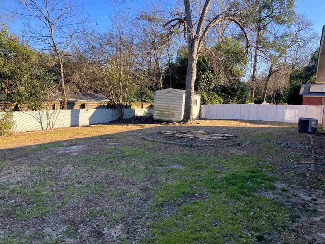 a view of yard with tree in the background