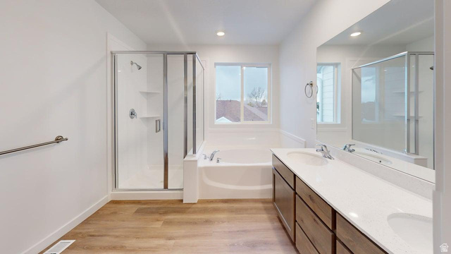777 Pheasantbrook Drive, Unit 2B Centerville, UT 84014 - Photo 15 of 42 Spacious bathroom featuring a double vanity with stone-finish countertop, wood-finish cabinetry, a large integrated mirror, a separate glass-enclosed shower, and a built-in bathtub with a window