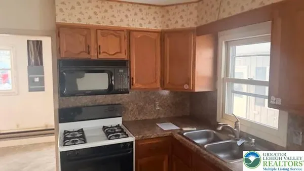 a kitchen with granite countertop a stove sink and cabinets