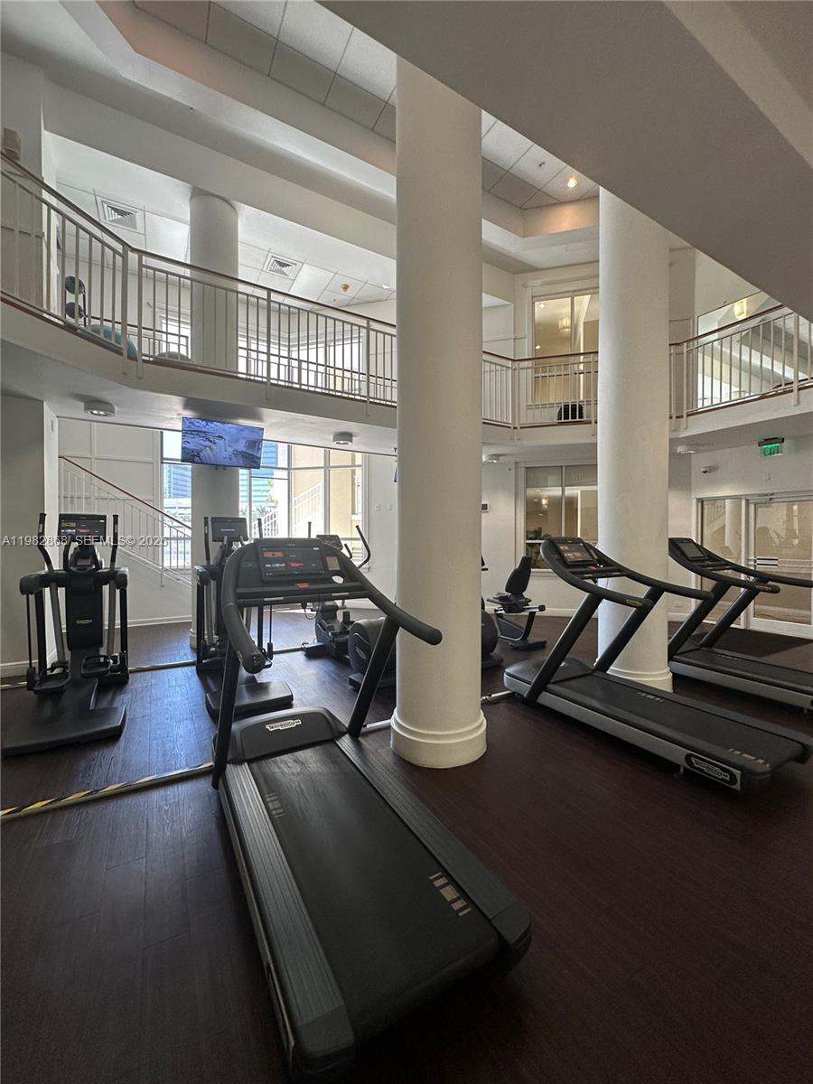 701 Brickell Key Boulevard, Unit 910 Miami, FL 33131 - Photo 22 of 30 a room with gym equipment and a large window