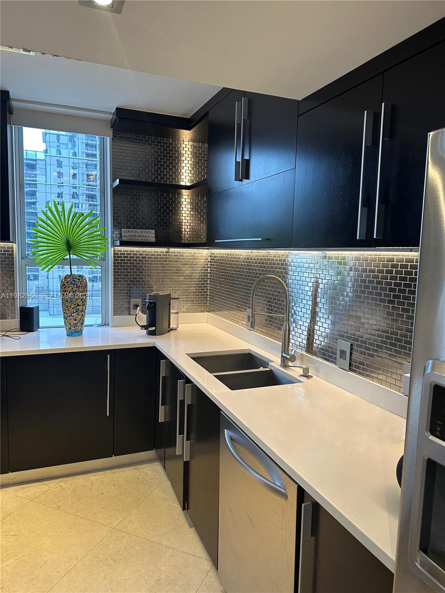 701 Brickell Key Boulevard, Unit 910 Miami, FL 33131 - Photo 6 of 30 a kitchen with a sink and wooden cabinets