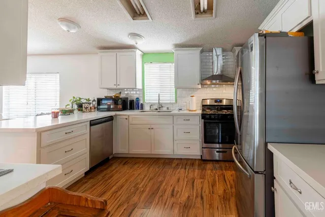 a kitchen with a white cabinets and wooden floor