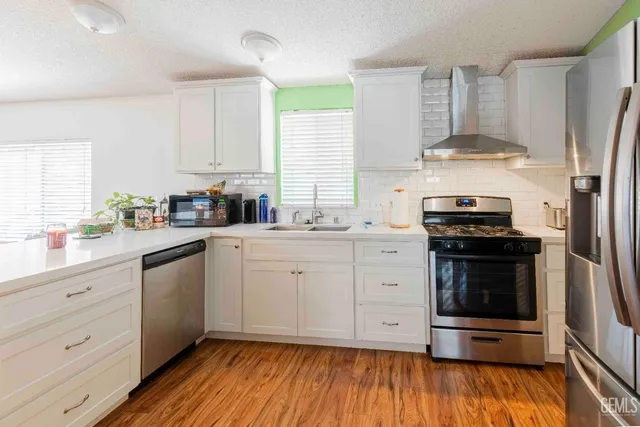 a kitchen with stainless steel appliances a refrigerator sink and microwave