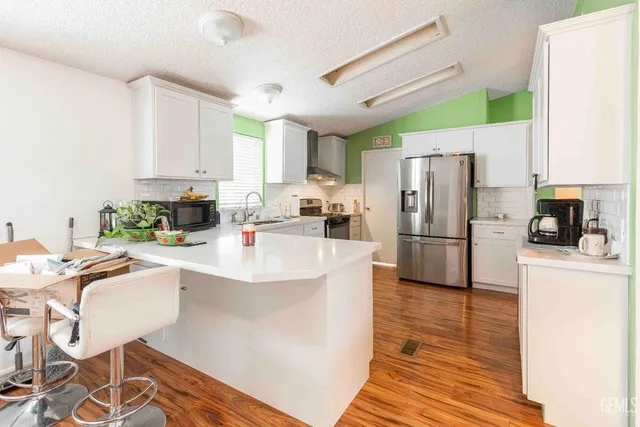 a view of a workspace with wooden floor and a window