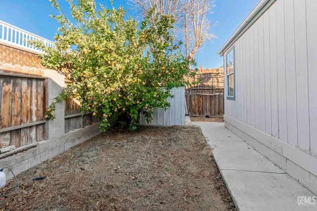 a view of a backyard with wooden fence