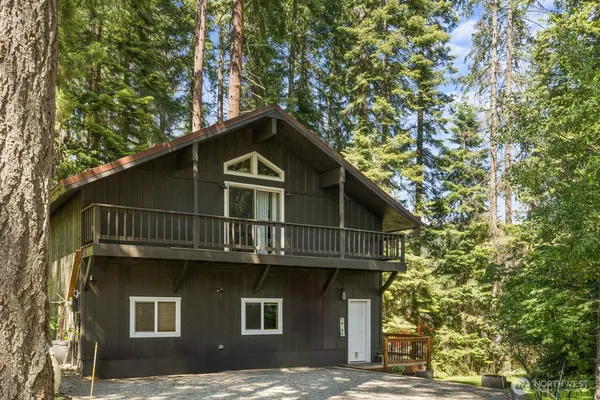 a front view of a house with a tree