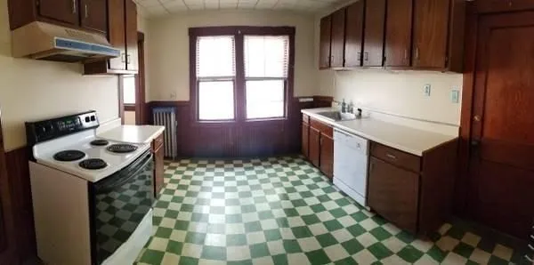 a kitchen with a sink a stove top oven and cabinets
