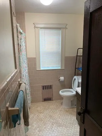 a bathroom with a toilet sink and mirror