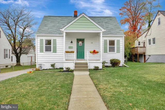 a front view of a house with a yard and trees