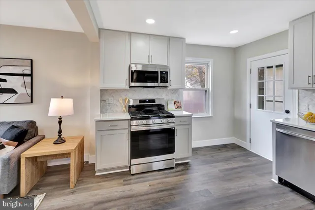 a kitchen with stainless steel appliances a stove microwave and sink