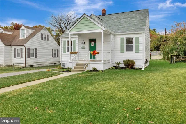 a front view of a house with a garden and trees