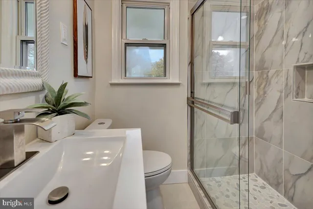 a bathroom with a toilet a sink and glass door