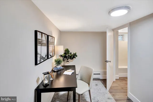 a view of a workspace room with furniture and wooden floor