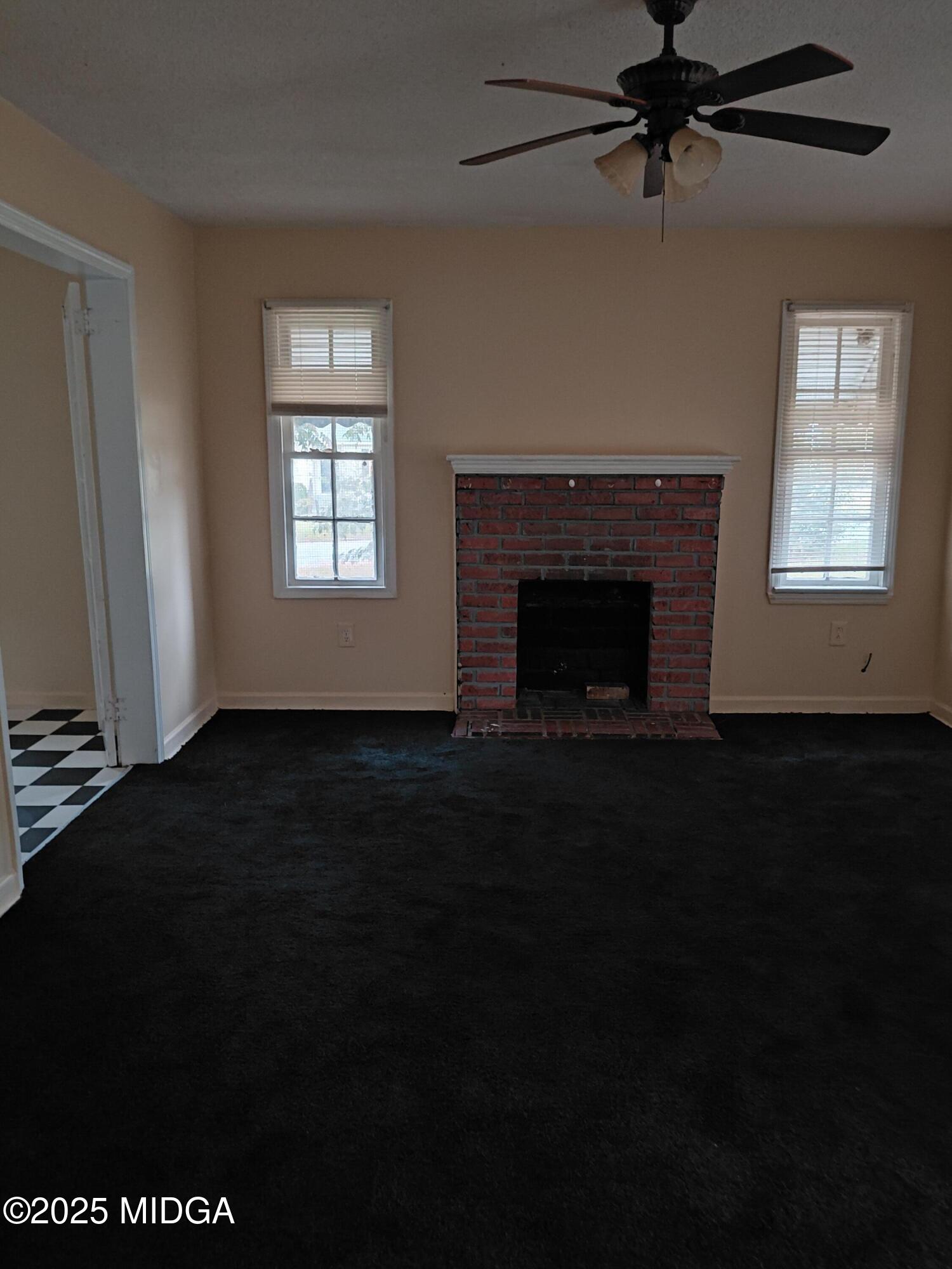 3811 Lyons Street Macon, GA 31206 - Photo 4 of 14 a living room with a black ceiling fan and a fireplace