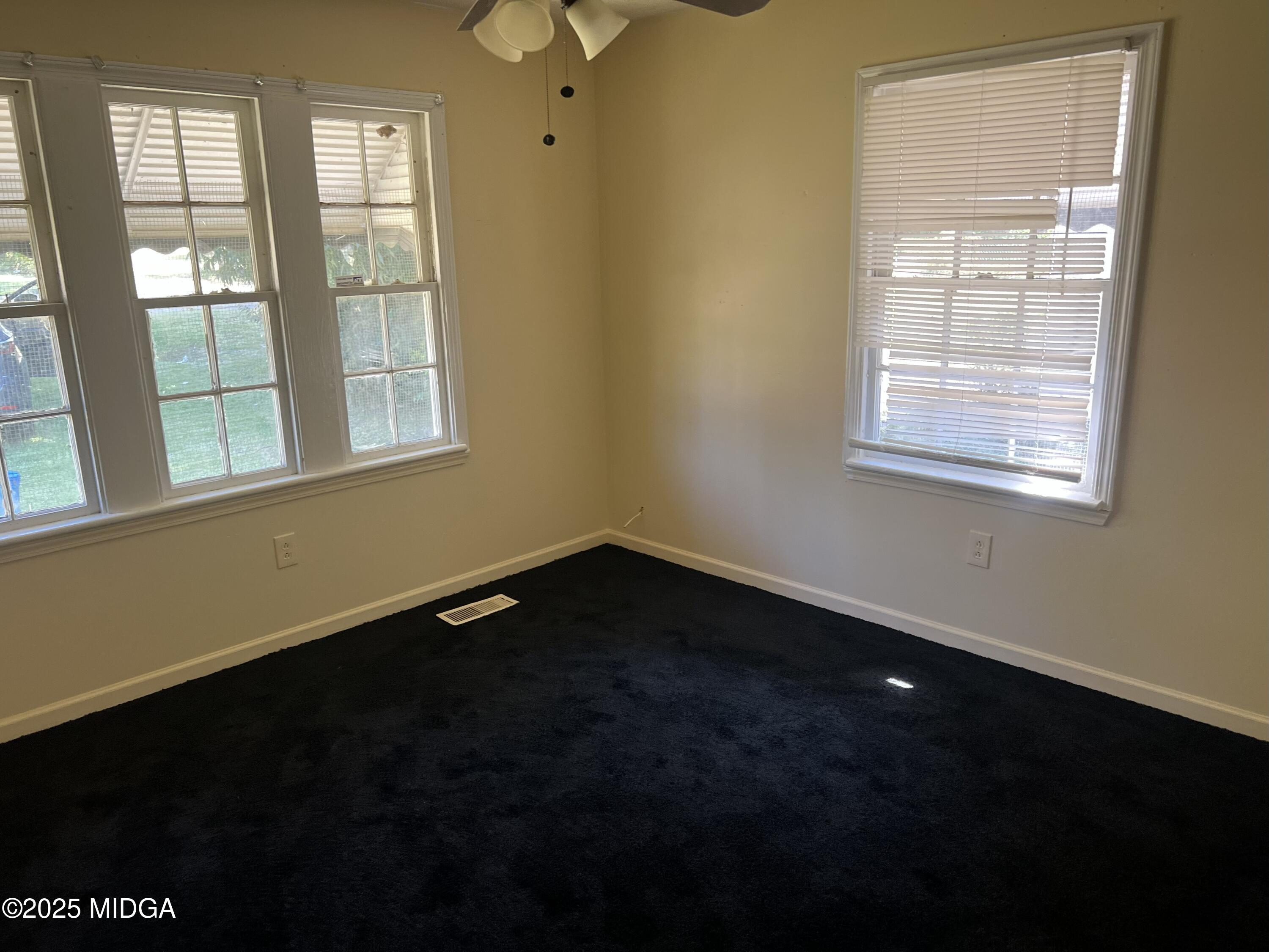 3811 Lyons Street Macon, GA 31206 - Photo 7 of 14 a view of an empty room with wooden floor and a window
