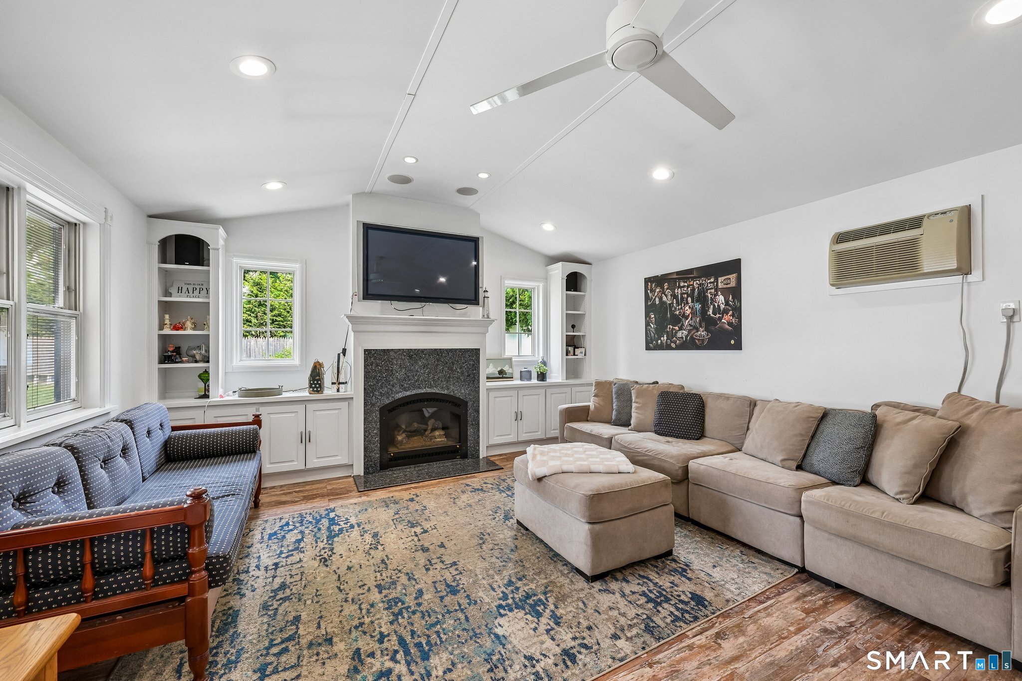 21 Friendly Road Norwalk, CT 06851 - Photo 1 of 28 Relax and unwind in this expansive Living Room with gas fireplace, plenty of light-filled windows and French doors to a patio. Built-ins add charm and vaulted ceilings make this room feel enormous! Recessed lighting and ceiling fans included.