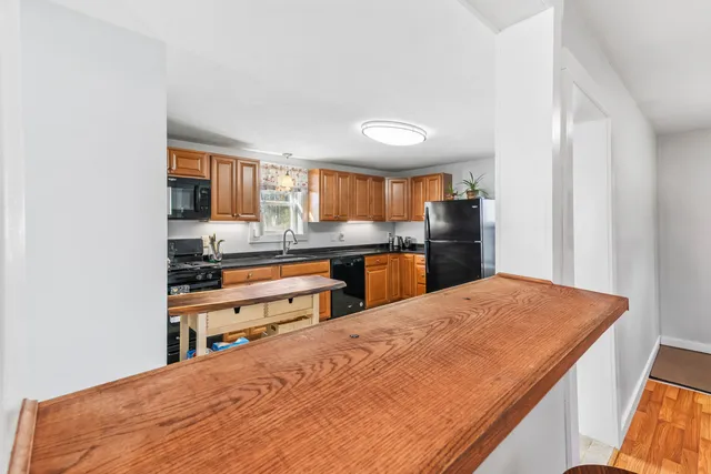 a kitchen with stainless steel appliances kitchen island granite countertop a refrigerator and cabinets