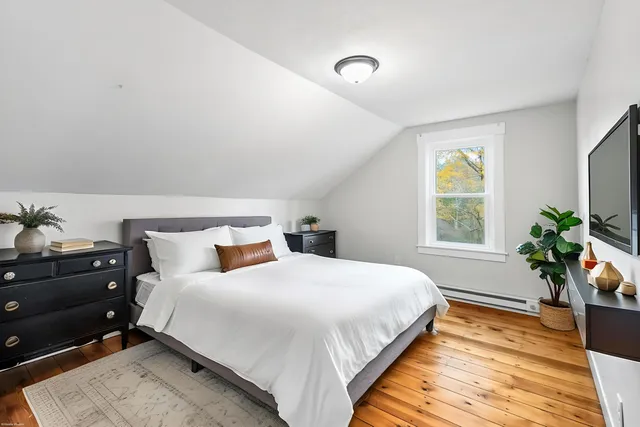 a bedroom with a bed and a potted plant