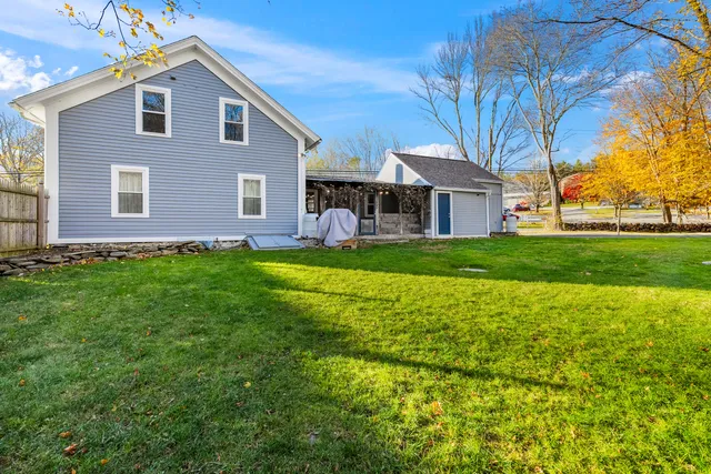 a view of a yard in front of a house with a large tree