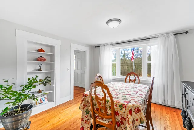 a dining room with furniture potted plants and wooden floor