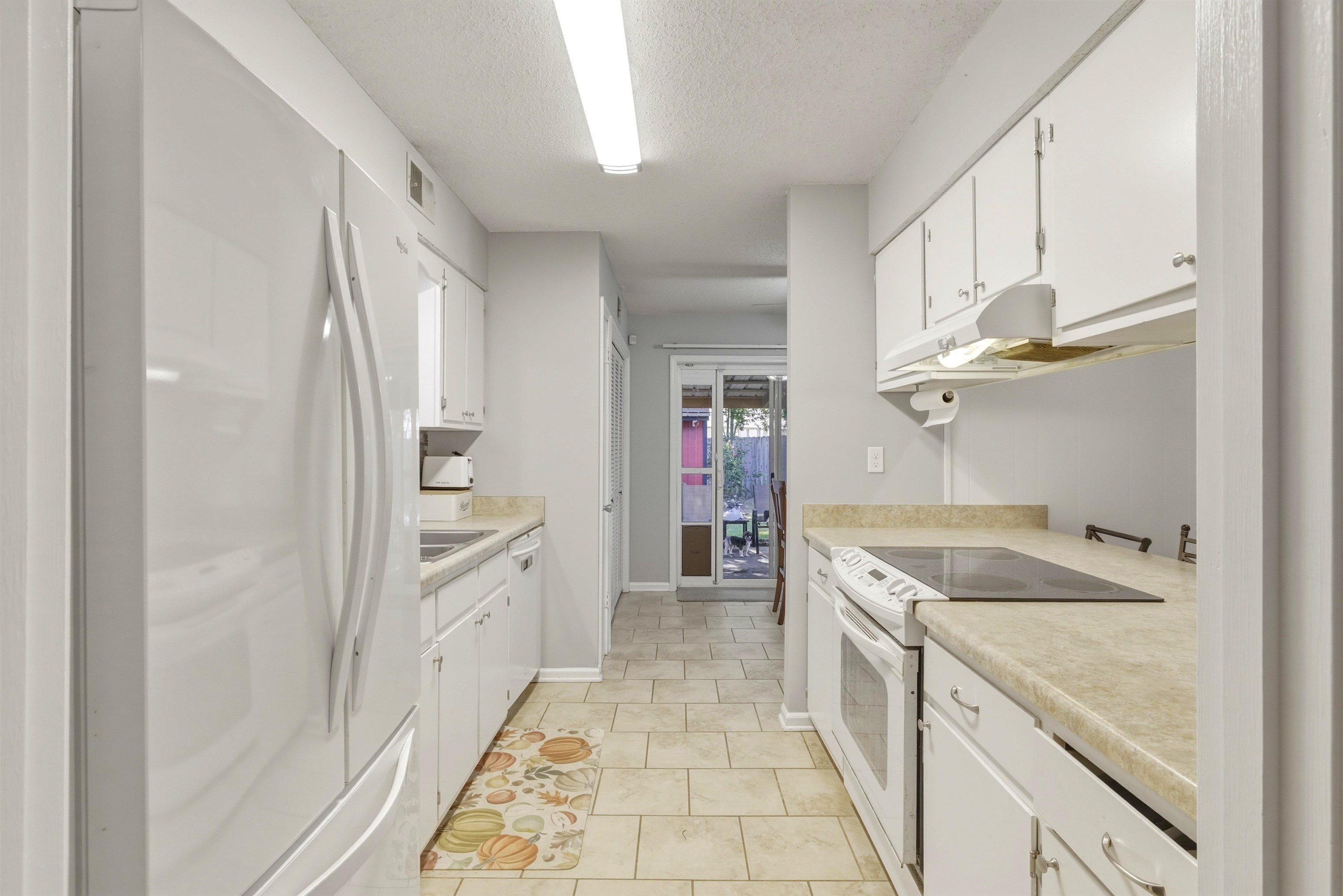 3276 Altruria Road Bartlett, TN 38134 - Photo 9 of 30 Galley kitchen featuring white cabinetry, light-toned countertops, and a full suite of white appliances including a refrigerator, range, and dishwasher