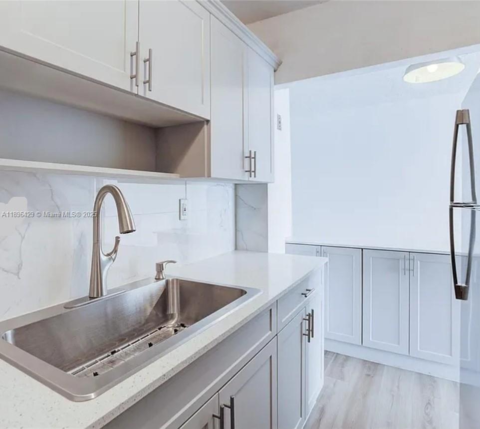 5501 Northwest 7th Street, Unit E408 Miami, FL 33126 - Photo 15 of 27 a kitchen with a sink cabinets and appliances