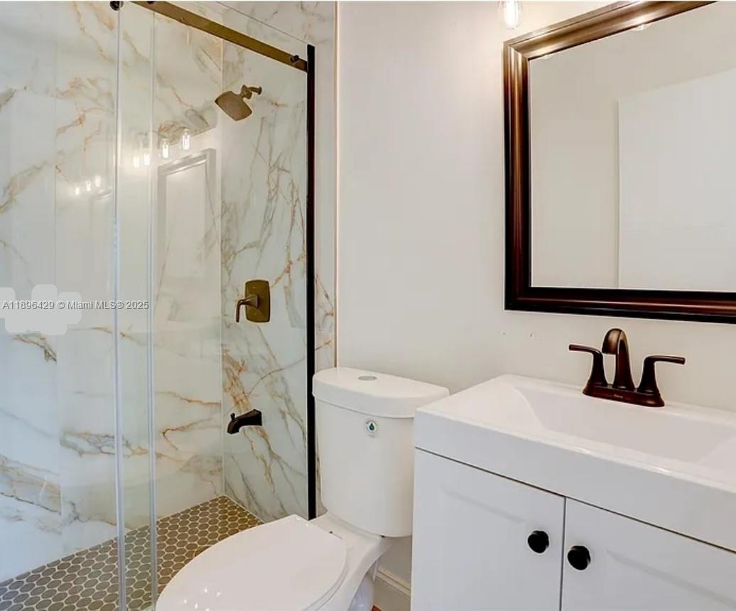 5501 Northwest 7th Street, Unit E408 Miami, FL 33126 - Photo 17 of 27 a bathroom with a sink a toilet and shower