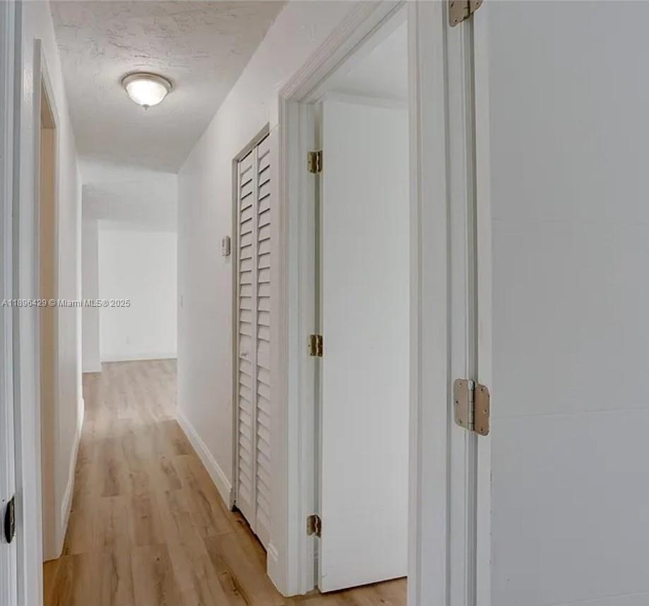 5501 Northwest 7th Street, Unit E408 Miami, FL 33126 - Photo 19 of 27 a view of a hallway with wooden floor and closet