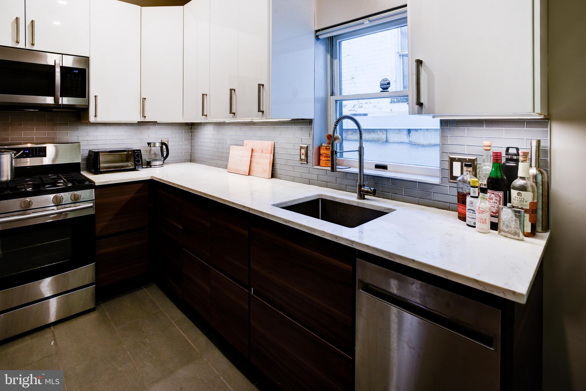 3026 R Street Northwest, Unit 2 Washington, DC 20007 - Photo 17 of 45 a kitchen with stainless steel appliances a sink stove and white cabinets