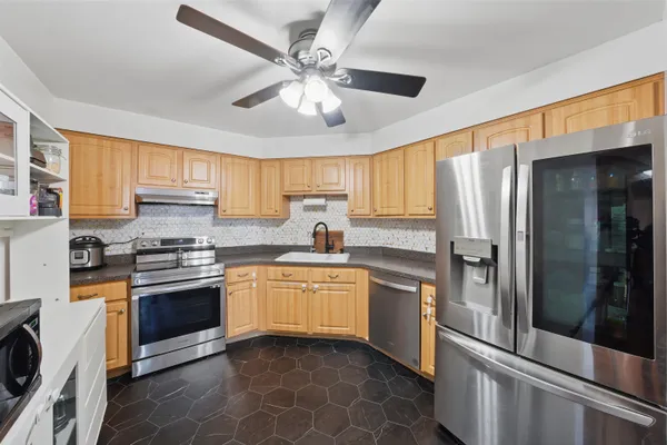 a kitchen with stainless steel appliances granite countertop a stove sink and refrigerator