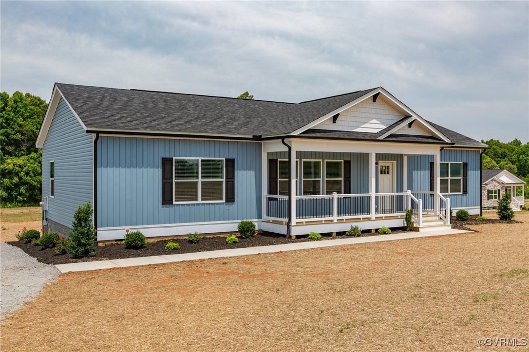 View of front of home with a porch and roof with s