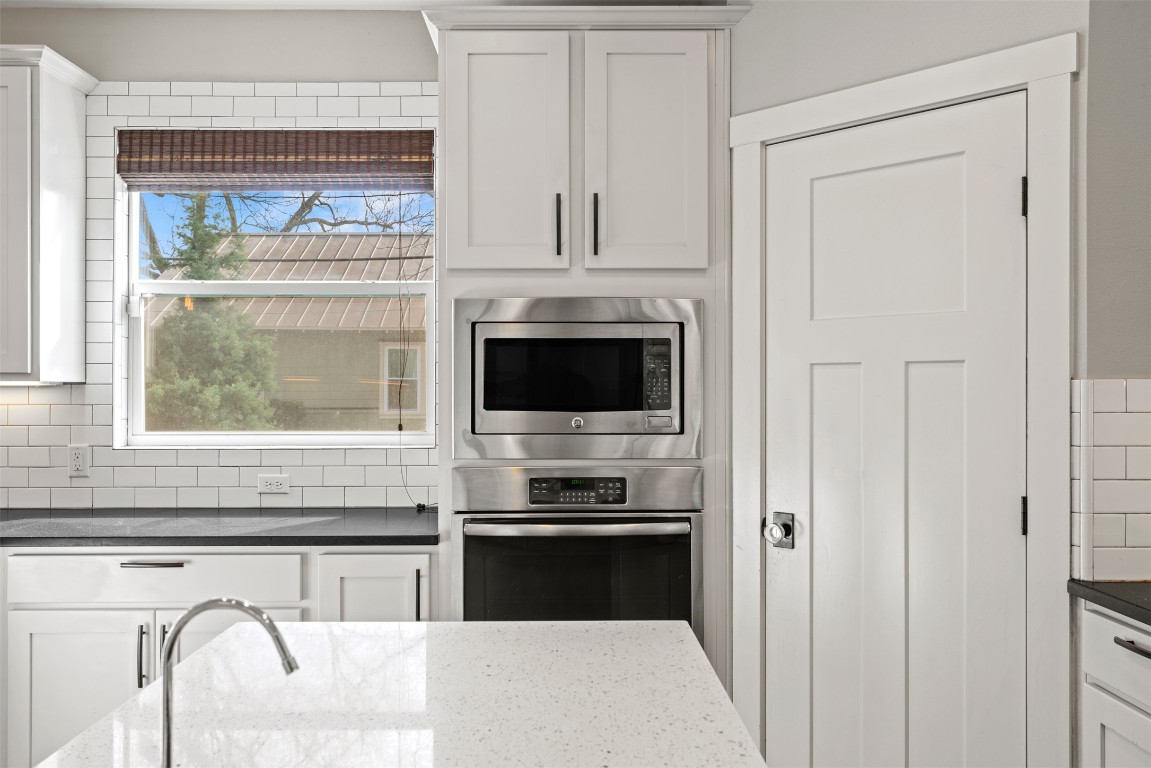 1912 South Church Street Georgetown, TX 78626 - Photo 13 of 40 a kitchen with granite countertop white cabinets and black appliances