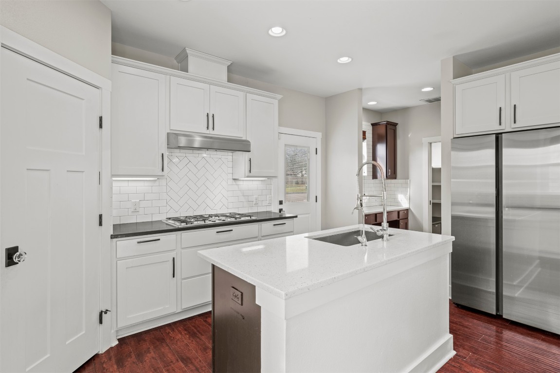 1912 South Church Street Georgetown, TX 78626 - Photo 15 of 40 a kitchen with a sink a stove a refrigerator and white cabinets