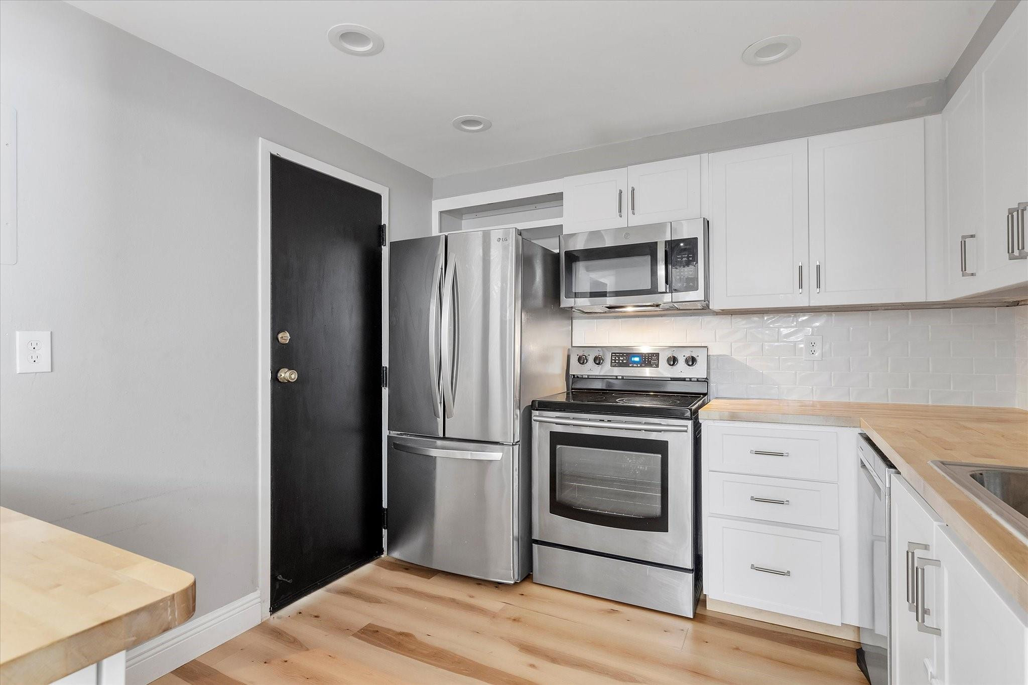 6500 Cypress Road, Unit 211 Plantation, FL 33317 - Photo 13 of 40 a kitchen with a refrigerator stove and white cabinets