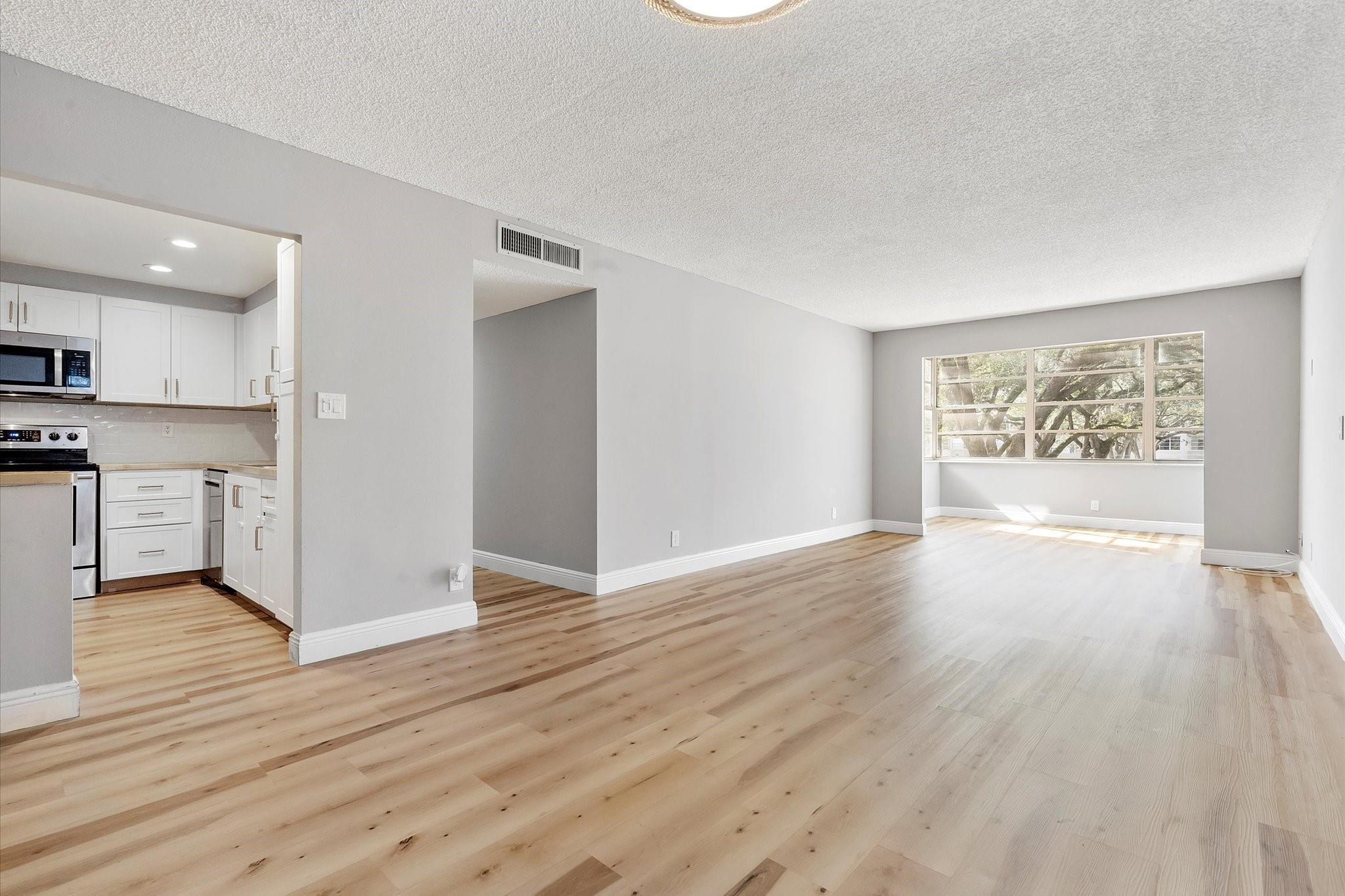 6500 Cypress Road, Unit 211 Plantation, FL 33317 - Photo 14 of 40 a view of an empty room with wooden floor and a window