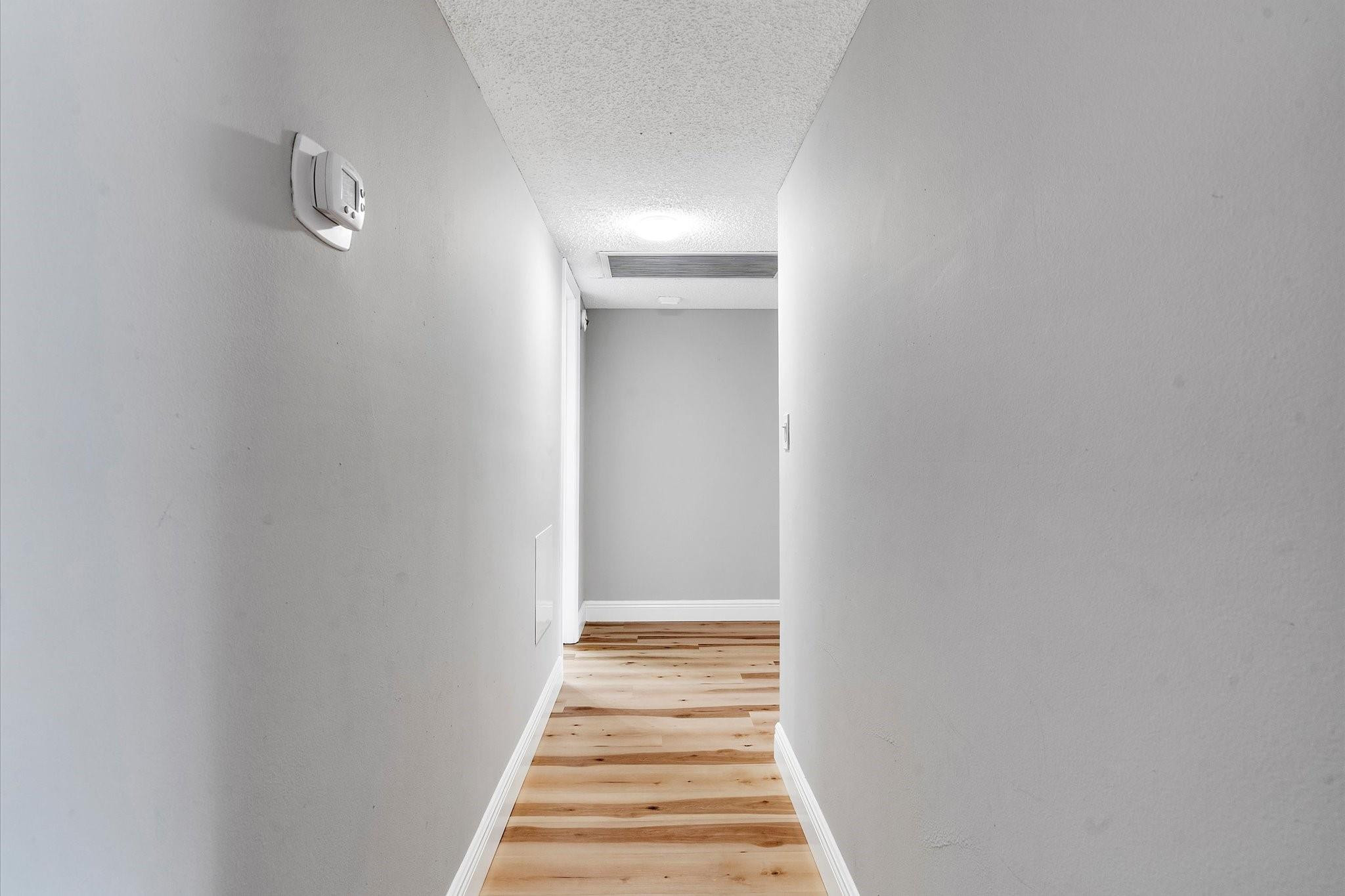 6500 Cypress Road, Unit 211 Plantation, FL 33317 - Photo 19 of 40 a view of a hallway with wooden floor and a bathroom