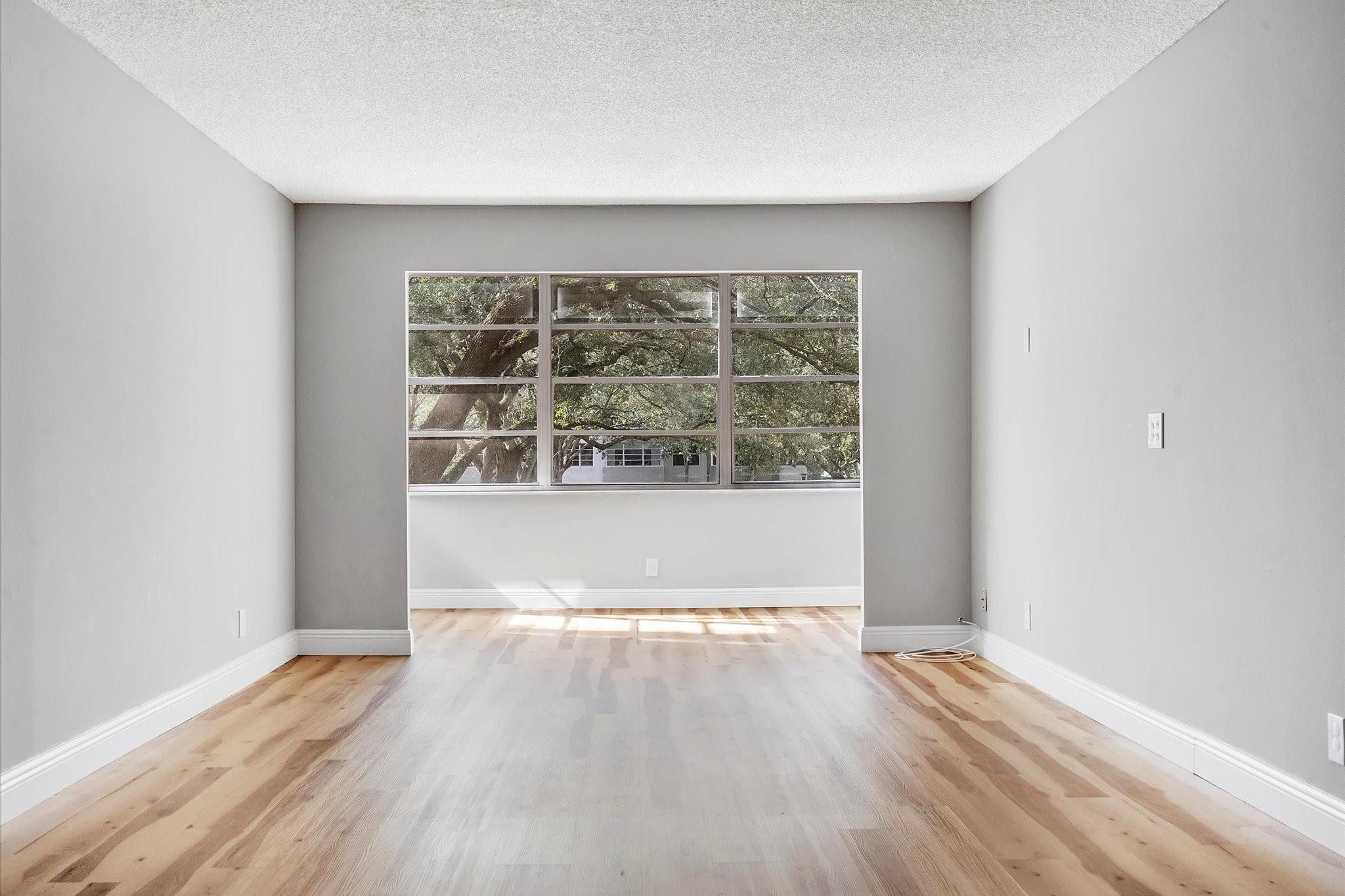 6500 Cypress Road, Unit 211 Plantation, FL 33317 - Photo 5 of 40 wooden floor in an empty room with a window