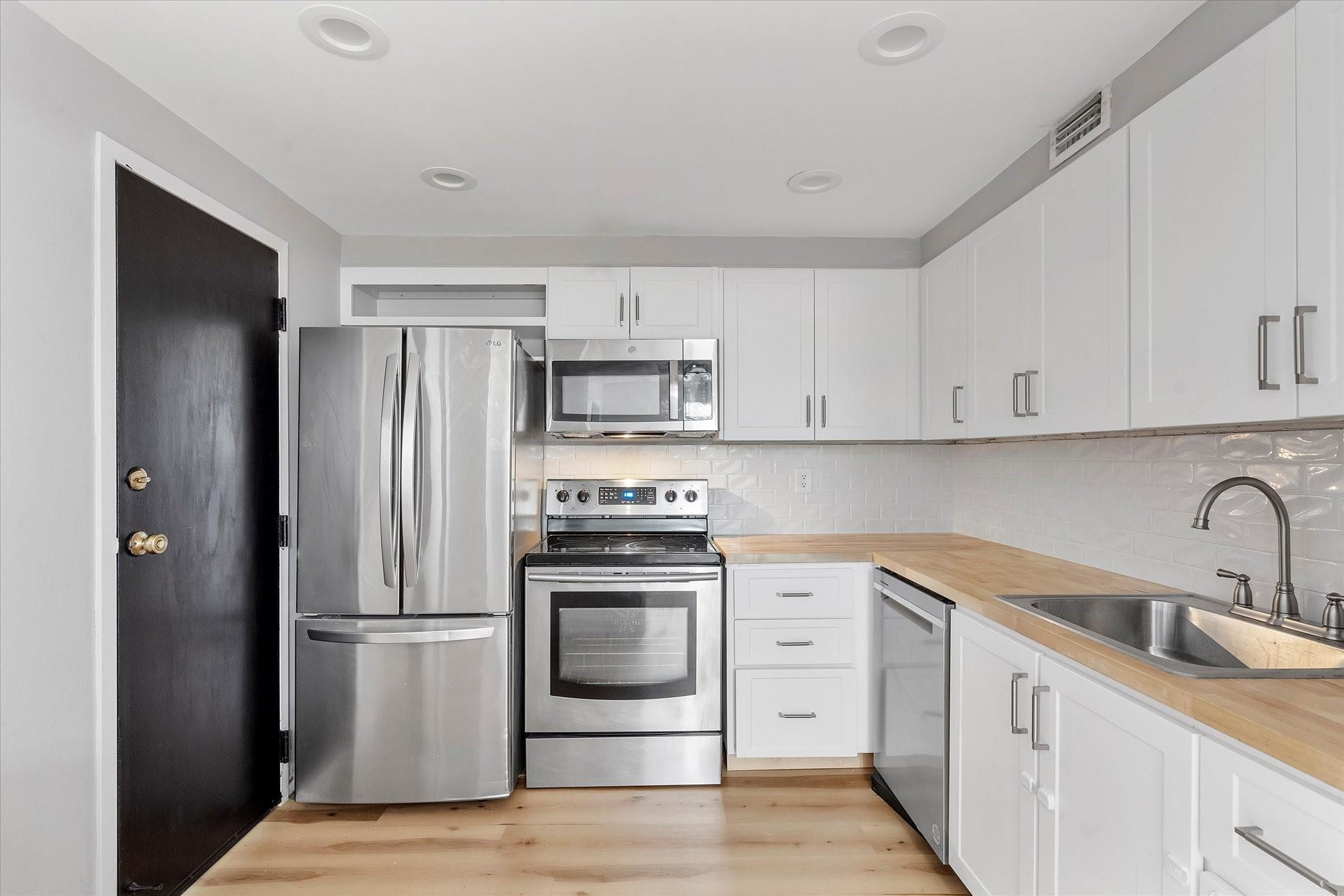 6500 Cypress Road, Unit 211 Plantation, FL 33317 - Photo 8 of 40 a kitchen with white cabinets and stainless steel appliances