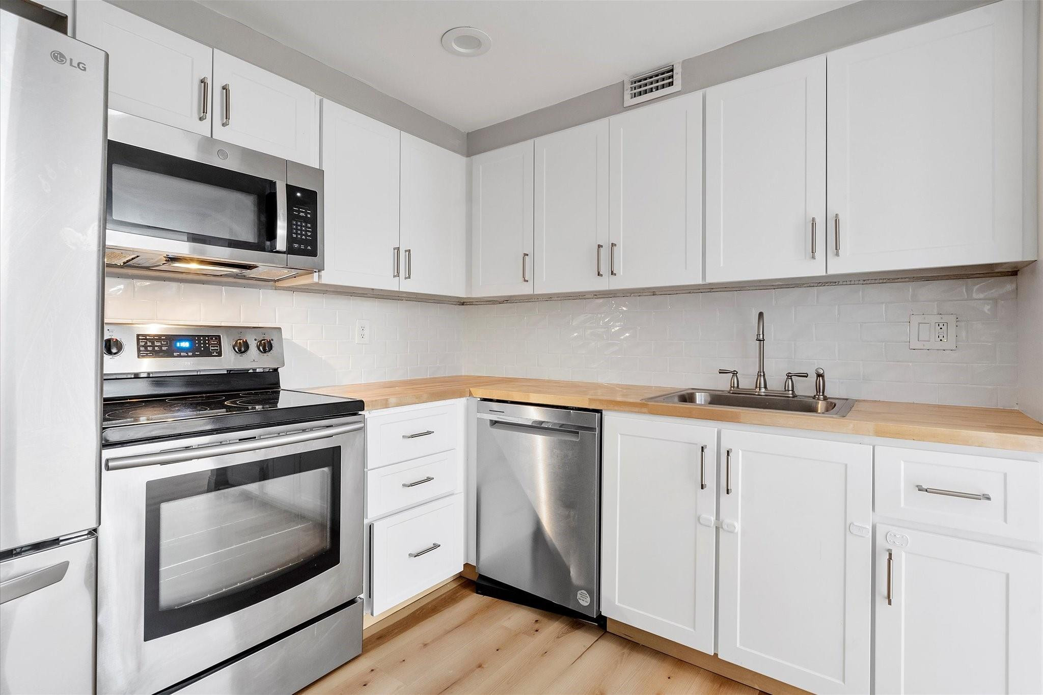 6500 Cypress Road, Unit 211 Plantation, FL 33317 - Photo 9 of 40 a kitchen with granite countertop white cabinets and stainless steel appliances